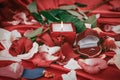 Candle and a diamond ring on a background of rose petals