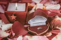 Candle and a diamond ring on a background of rose petals