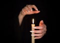 Candle and female witch hands with sharp pearl nails. Divination and witchcraft, low key. Royalty Free Stock Photo