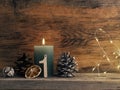 Candle of the first Advent burns, pine cones and Christmas decoration on wood Royalty Free Stock Photo