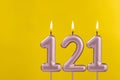 Candle 121 with flame - Birthday card on yellow luxury background