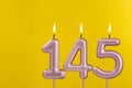 Candle 145 with flame - Birthday card on yellow luxury background