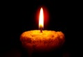 Candle with a flame on a black background. Romantic setting. Royalty Free Stock Photo