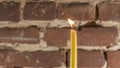 Candle flame close-up on a light red wall background. Melted Wax Candle light border design. Long Exposure