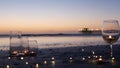 Candle flame lights in glass, romantic beach date by ocean waves, summer sea. Candlelight on sand.