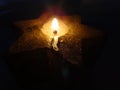 Candle flame in the shape of a star on a black background. Royalty Free Stock Photo