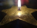 Candle flame in the shape of a star on a black background with reflections Royalty Free Stock Photo