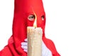 The candle in flame of a young Nazarene with a red hood doing his penance station in the Holy Week procession. Royalty Free Stock Photo