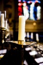 Candle flames in the Christian church. Group of yellow candles at the church. Dark mood with burnt candles. Royalty Free Stock Photo