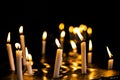 Candle flames in the Christian church. Group of yellow candles at the church. Dark mood with burnt candles. Royalty Free Stock Photo