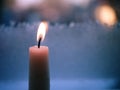 Candle flickers in cold winter window background