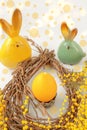 Candle in the form of an Easter egg in a nest. Easter decoration on a wooden table