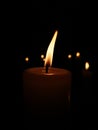 A Candle in front ot more candles, in the dark Royalty Free Stock Photo