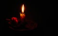 Candle gently lighting a red rose. Royalty Free Stock Photo