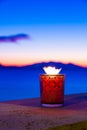 Candle glass at sunset in italy, sea and Elba island, in the background