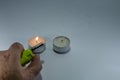 Candle and green lighter with hand on white background