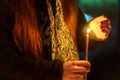 A candle in the hands of a praying woman. Symbolic concept. Background with selective focus Royalty Free Stock Photo