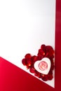 Candle heart on the heart of rose petals corner red white background with space for text Royalty Free Stock Photo