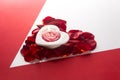 Candle heart on the heart of rose petals corner red white background with space for text Royalty Free Stock Photo