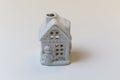 Candle holder in shape of snowy house on white background