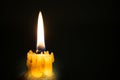 Portrait of a burning candle in the dark background