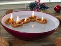 Candle inside walnuts shell floating on water inside bowl