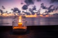 Candle lamp on table with sea and sunset background Royalty Free Stock Photo