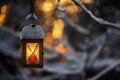 Candle lantern hanging from tree branch, bokeh winter background Royalty Free Stock Photo