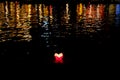 Candle lanterns floating on a river among colorful reflections during night in Hoi An, Vietnam Royalty Free Stock Photo