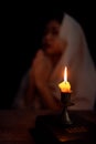Candle light with blur young girl praying in dark night background. Woman person worship God with faith and belief. religion, Royalty Free Stock Photo