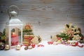 Candle light lantern, fir branches, baubles, gingerbread cookies and other Christmas decoration arranged against a white wooden Royalty Free Stock Photo