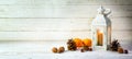candle light lantern with pine cones, nuts and tangerines as christmas decoration on a wide, bright wooden background, panoramic Royalty Free Stock Photo
