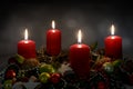 Candle light in the night, part of an Advent wreath with four red candles and Christmas decoration against a dark background, copy Royalty Free Stock Photo