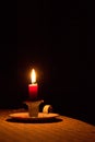 Candle light on a table, shining in the dark. Power outage, blackout concept. Royalty Free Stock Photo