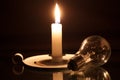 Candle and a lightbulb on a black background. A concept of electricity crisis in South Africa. Royalty Free Stock Photo