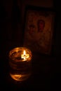 Candle lights with flame glowing on oil in the interior of a church. Symbol of faith and spirit