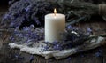 A candle is lit in front of a bunch of lavender flowers Royalty Free Stock Photo