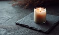 A candle is lit and sitting on a stone surface Royalty Free Stock Photo