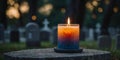 A candle is lit on a stone ledge in a cemetery. Royalty Free Stock Photo