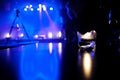 Candle lit on a table in a club with blue lit stage in the background