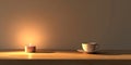 A candle is lit on a table next to a white cup Royalty Free Stock Photo