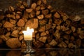 Candle with logs on a background and reflection on a floor.