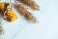 Candle made from natural beeswax on a light background with pampas grass