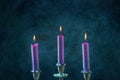 Candle magic. Purple candles burning on a dark blue background