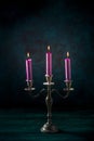 Candle magic. Purple candles in a vintage candleholder