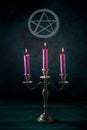 Candle magic. Purple candles in a vintage candleholder with a pentagram