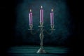 Candle magic. Purple candles in a vintage candle holder