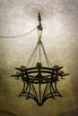 8 candle medieval chandelier hanged by chains over a pulley