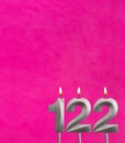 Candle number 122 - Birthday celebration on fuchsia background