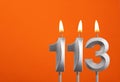 Candle number 113 - Birthday in orange background
